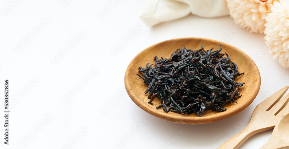 seaweed sargassum fusiforme or Hijiki seaweed in wood plate on white background seaweed sargassum fusiforme or Hijiki seaweed in wood plate on white background