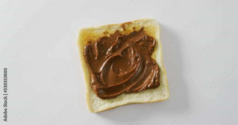 Video of close up of toast with chocolate cream on white background Video of close up of toast with chocolate cream on white background