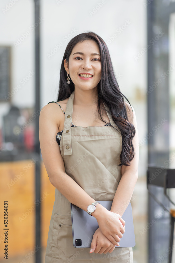 Startup successful small business owner sme beauty girl stand with tablet in coffee shop restaurant. Portrait of asian tan woman barista cafe owner. SME entrepreneur seller business concept Startup successful small business owner sme beauty girl stand with tablet in coffee shop restaurant. Portrait of asian tan woman barista cafe owner. SME entrepreneur seller business concept
