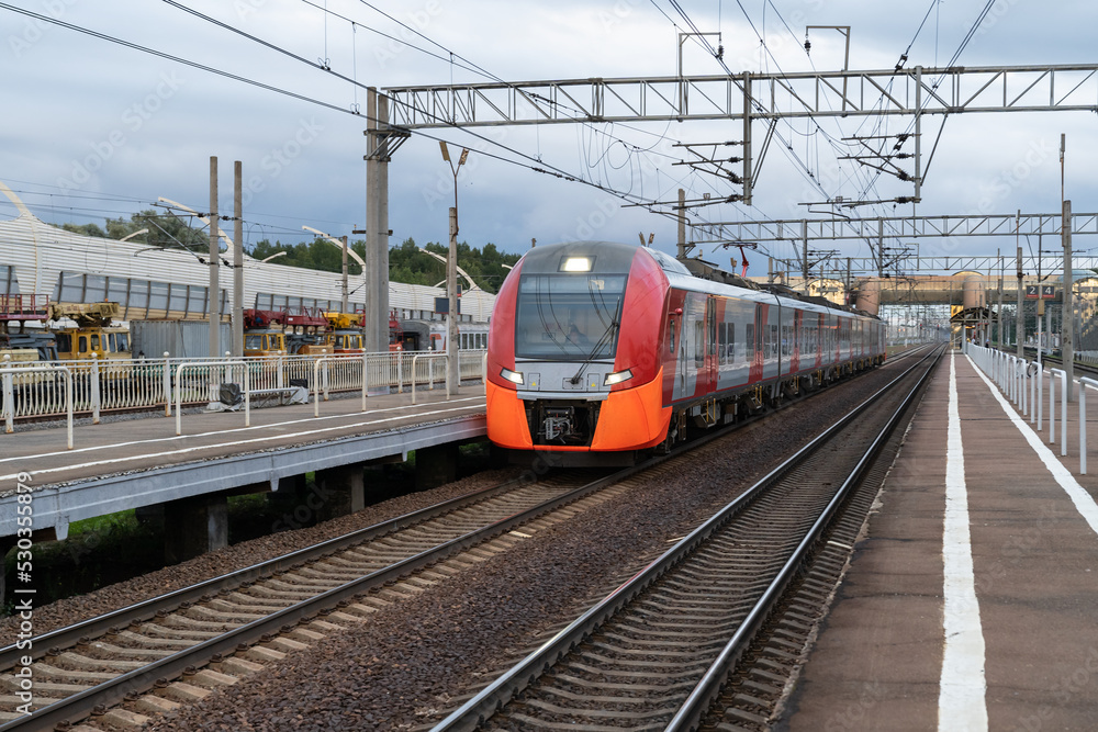 High-speed train arrives to empty railway terminal on nasty day. Express train waits for new passengers to reach destination. Modern technology makes possible for people to travel around world