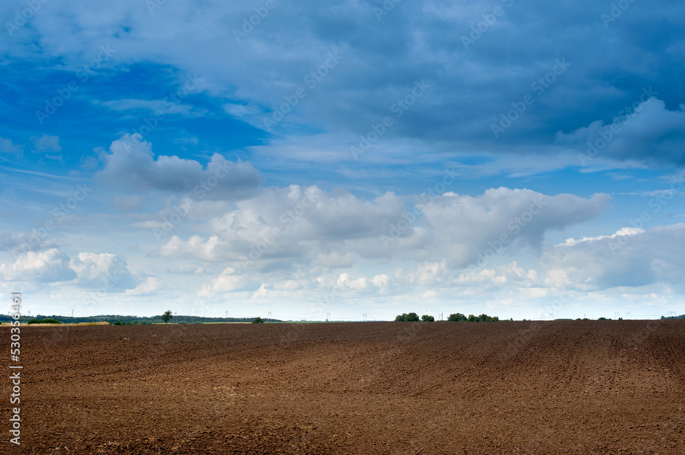 areas of arable fields, landscape, preparation for sowing for the season Agriculture, agrarian plowed areas, and beautiful blue sky with clouds areas of arable fields, landscape, preparation for sowing for the season Agriculture, agrarian plowed areas, and beautiful blue sky with clouds