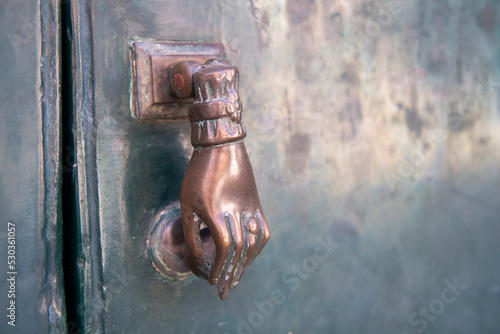 vintage hand doorknocker on entrace photo