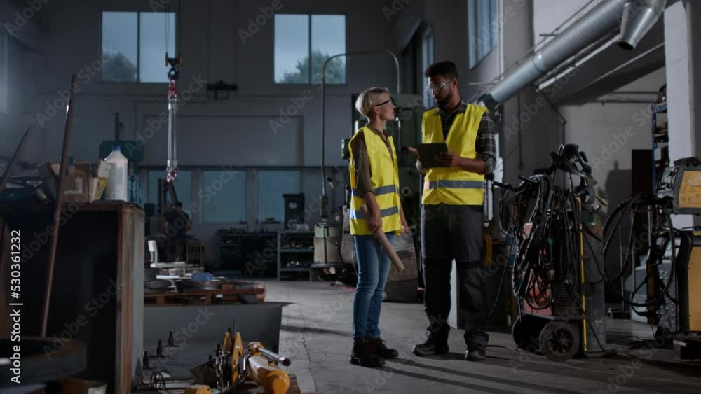 Two heavy indrustry workers consulting, using tablet. Two heavy indrustry workers consulting, using tablet.