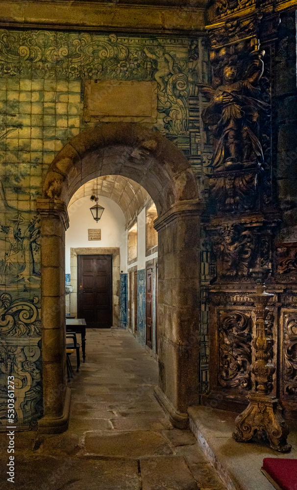 Interior of Viseu Cathedral. Mosaics with tiles and entrances with arches decorated with religious faces carved in wood
