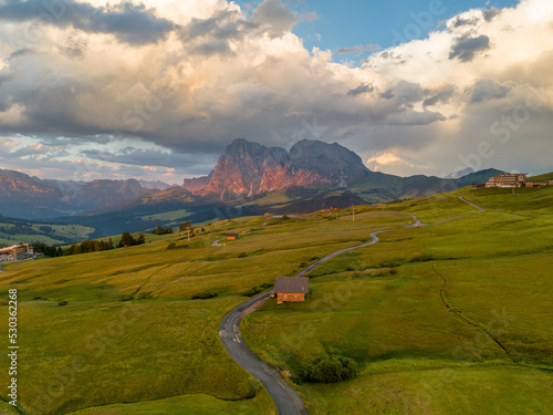 Sunrise in the Dolomites mountains with fog and mist rolling around the peaks. Hiking path leading to the hills. 