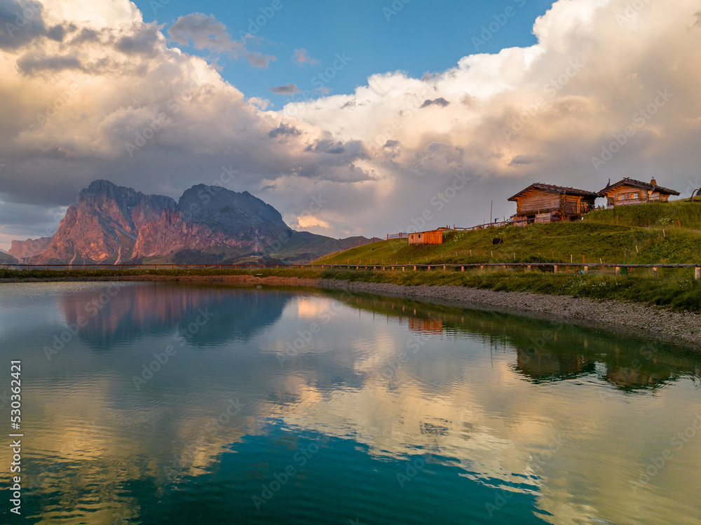 Sunrise in the Dolomites mountains with fog and mist rolling around the peaks. Hiking path leading to the hills. 