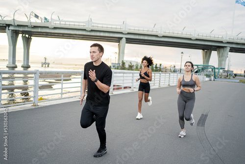 Young people sports friends are doing a fitness workout in the city. A healthy lifestyle is used by fitness watches.