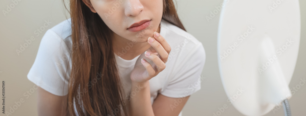 skin problem treatment. Women looking acne on her face in the mirror.