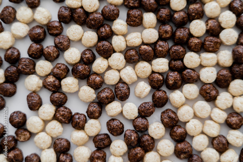 background of cereal balls with vanilla and chocolate flavors on white.