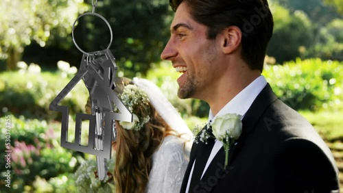 Animation of housekey moving over happy caucasian couple walking towards aisle at wedding photo