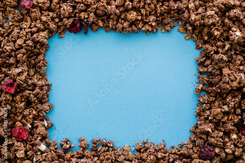 top view of frame made of crunchy and sweet oat granola isolated on blue. © LIGHTFIELD STUDIOS