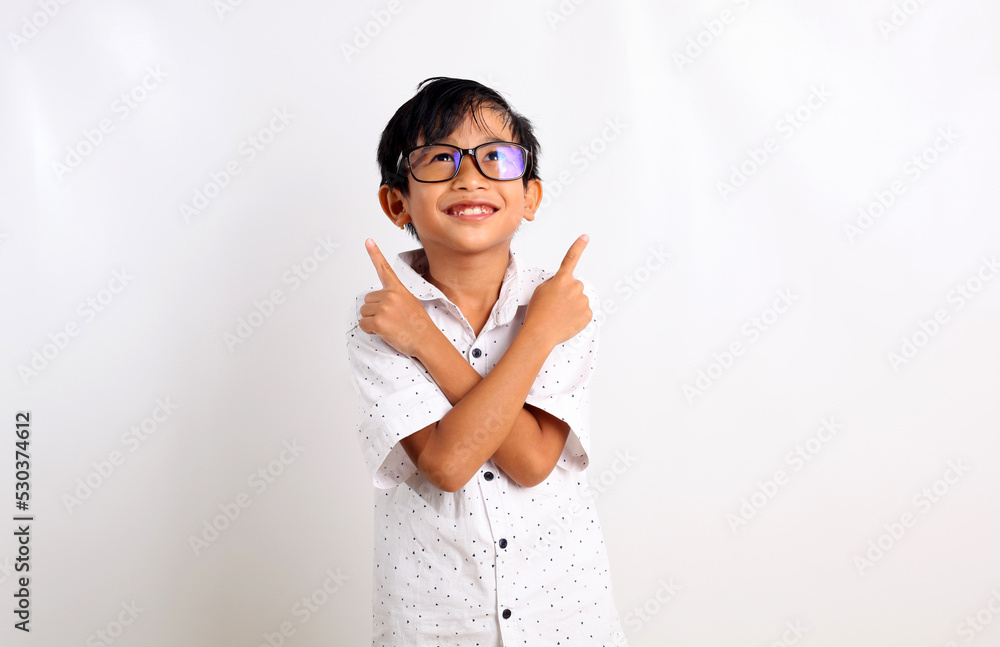 Happy asian boy standing while pointing up with both hand. Isolated on white background Happy asian boy standing while pointing up with both hand. Isolated on white background