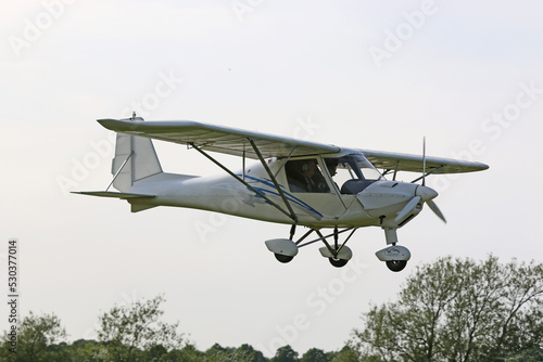 Ultralight airplane flying in a blue sky photo