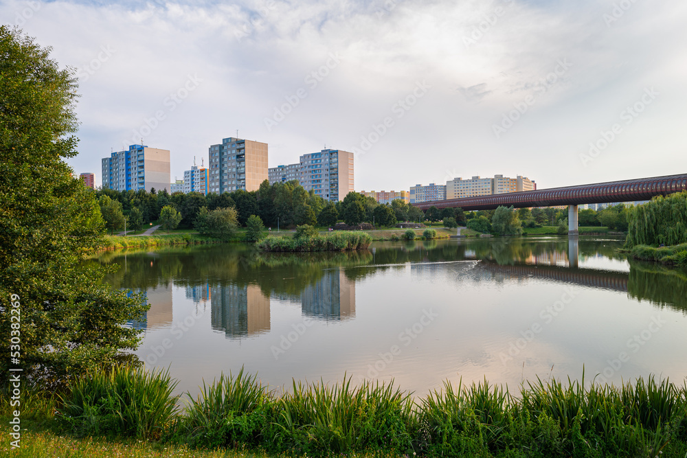 Small lake in a city park and high-rise apartment buildings in suburban area Lužiny in the city of Prague