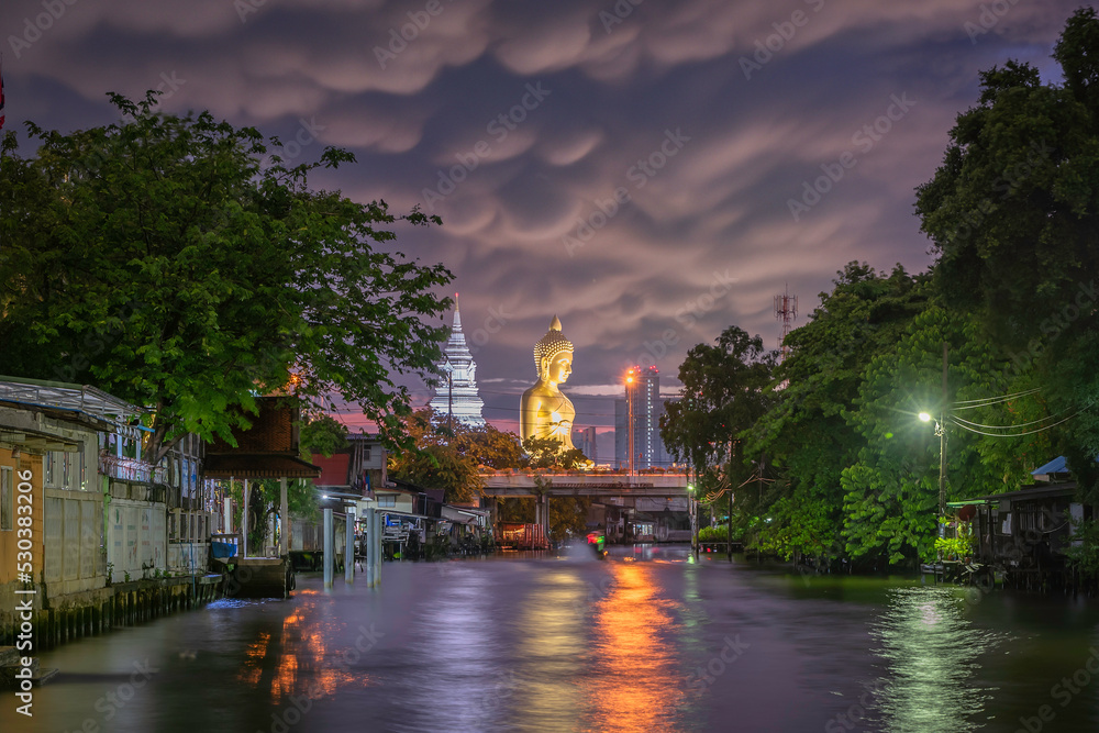 picture of lifestyle along the canal of Bangkok Yai see the big golden Buddha Amid the strange clouds at night