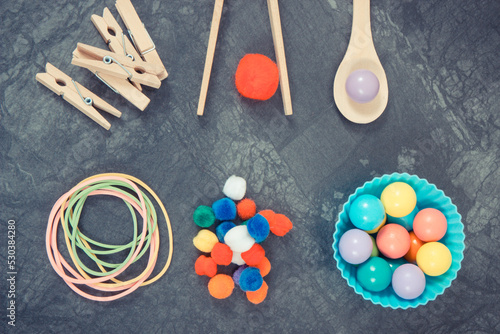 Colorful pompoms, balls and rubber erasers using for playing and development of kids motor skills, coordination and logical thinking
