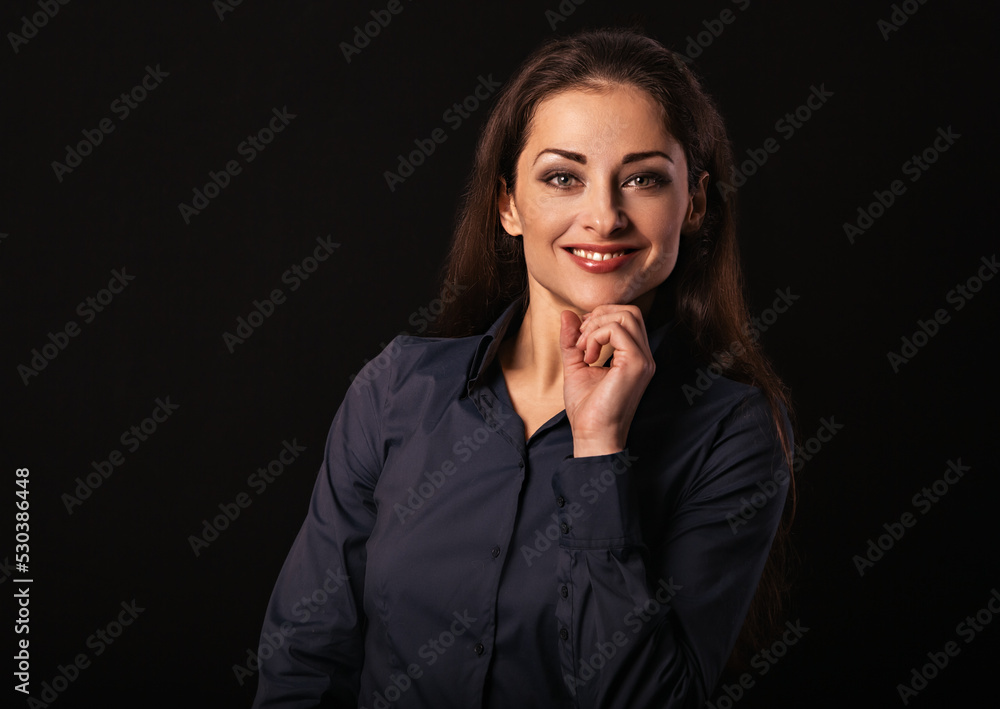 Beautiful thinking toothy smiling business woman with folded arms in blue shirt on black background with empty copy space for text. Closeup toned color vintage Beautiful thinking toothy smiling business woman with folded arms in blue shirt on black background with empty copy space for text. Closeup toned color vintage