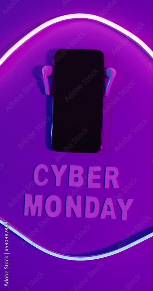 Vertical video of earphones and smartphone with cyber monday text and light on purple background Vertical video of earphones and smartphone with cyber monday text and light on purple background