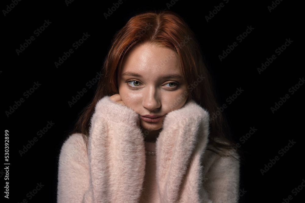 Gentle portrait of a girl in pink clothes on a black background. Young girl with red hair Gentle portrait of a girl in pink clothes on a black background. Young girl with red hair