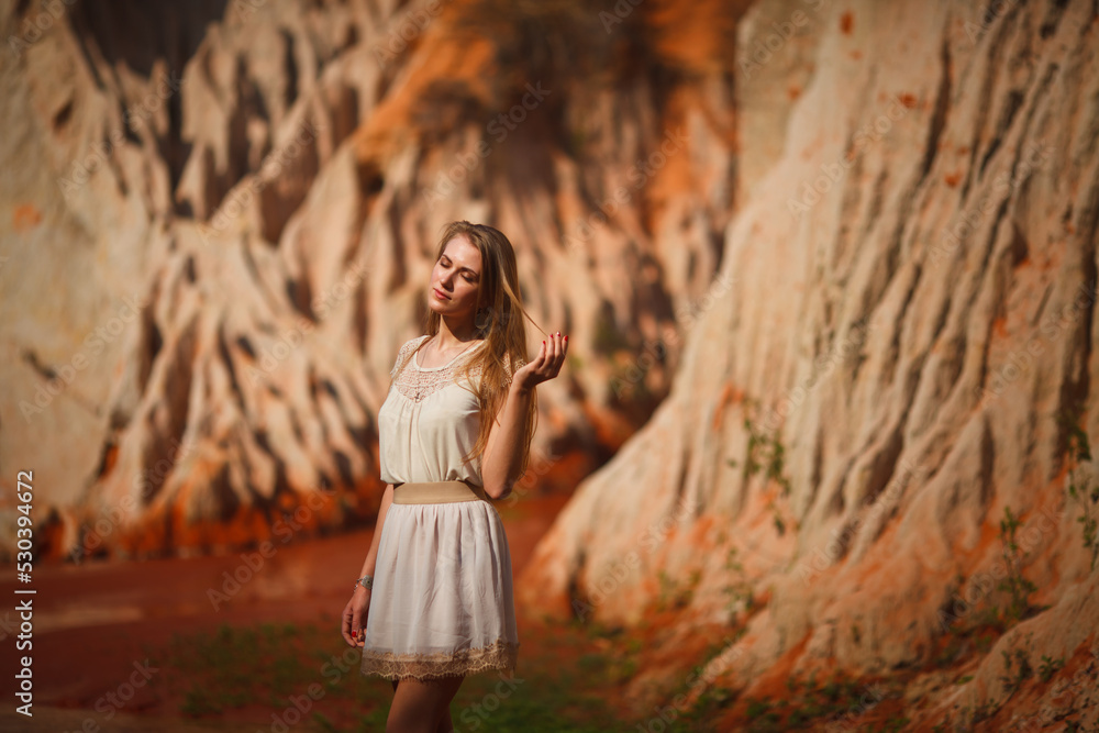 A beautiful young woman walks along a stream in the tropics. Vietnam Mui Ne. Blonde in the tropics A beautiful young woman walks along a stream in the tropics. Vietnam Mui Ne. Blonde in the tropics