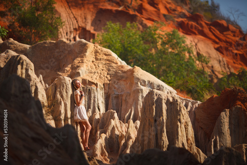 A beautiful young woman walks along a stream in the tropics. Vietnam Mui Ne. Blonde in the tropics