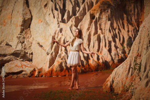 A beautiful young woman walks along a stream in the tropics. Vietnam Mui Ne. Blonde in the tropics