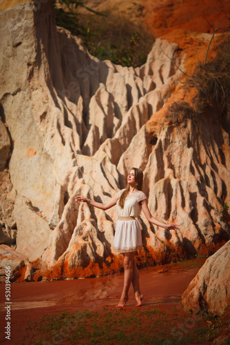A beautiful young woman walks along a stream in the tropics. Vietnam Mui Ne. Blonde in the tropics