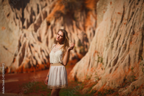 A beautiful young woman walks along a stream in the tropics. Vietnam Mui Ne. Blonde in the tropics