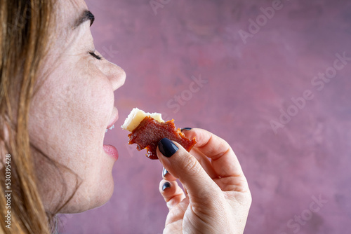 Woman going to bite slices of guava sweet and cheese. photo