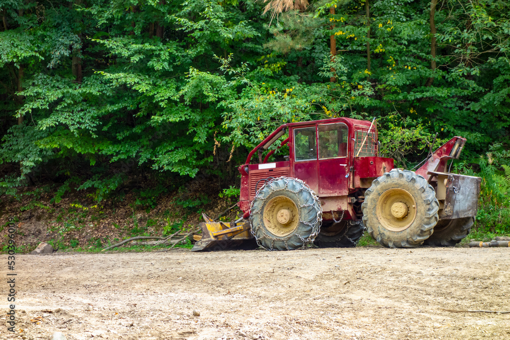 Logging tractor for harvesting felled trees in the forest Logging tractor for harvesting felled trees in the forest