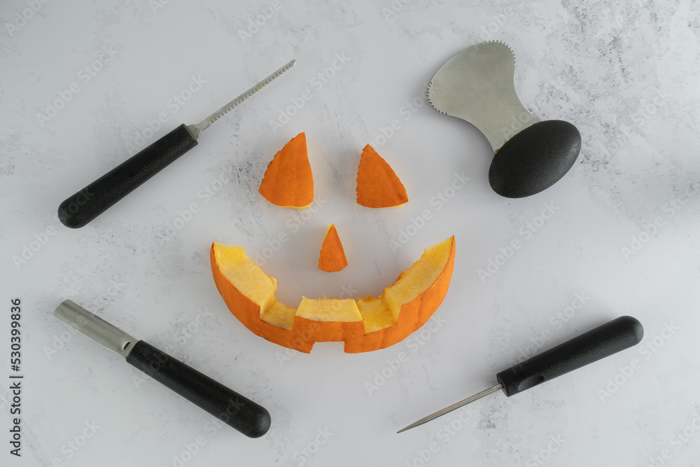 Halloween pumpkin pieces. Spooky laughing, scary carved Jack Lantern eyes,  nose, mouth. Jack-o'-lantern elements with carving tools - spoon, saw  blade, pointed and grove carver. Photos | Adobe Stock