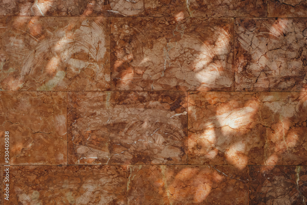 Shadows on a wall made of big brown abstract tiles. Texture, background for design.