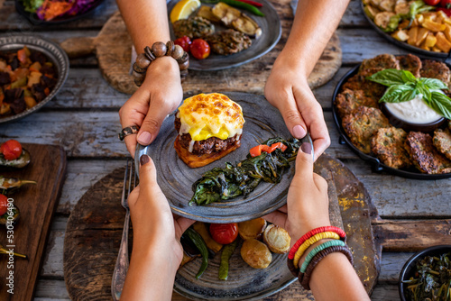 Meatball with potatoes puree and cheese at the hands of two women. Hasanpasa Kofte  photo