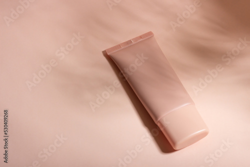 Bild auf Leinwand Cosmetic cream or mask in a white tube with hard shadows from the leaves on a white background