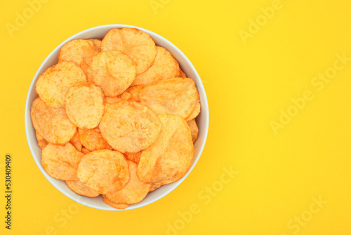 Vessel with Potato Chips on yellow background. Fast Food concept