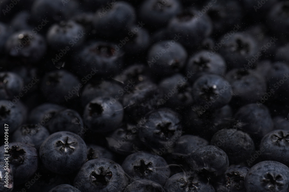 a heap of fresh ripe wet blueberries under water filling the frame, selective focus, top view, background a heap of fresh ripe wet blueberries under water filling the frame, selective focus, top view, background