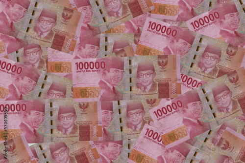 Group of money stack of 100.000 rupiah banknotes a lot of the background texture top view photo