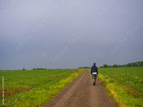 person walking on a gravel road in the countryside