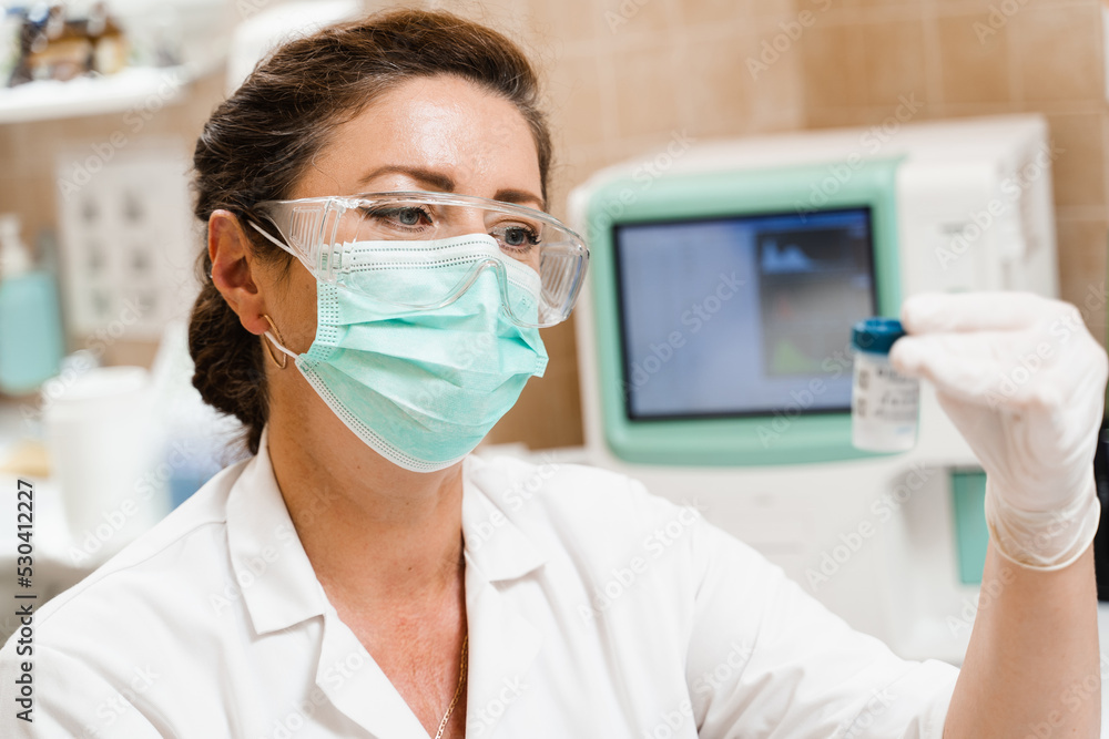 Laboratory assistant holds test tubes for gynecological and cytological analysis. Woman scientist working in medical lab. Laboratory assistant holds test tubes for gynecological and cytological analysis. Woman scientist working in medical lab.