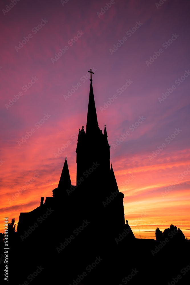 Church building exterior in silhouette of  landscape sunset 