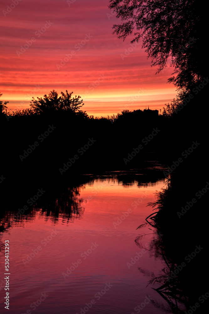 beautiful sunset in autumn season. trees silhouette near a river beautiful sunset in autumn season. trees silhouette near a river