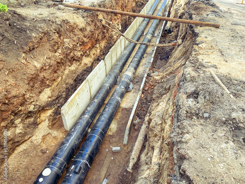 black, polypropylene, long pipes are laid underground for communications. construction of a new neighborhood
