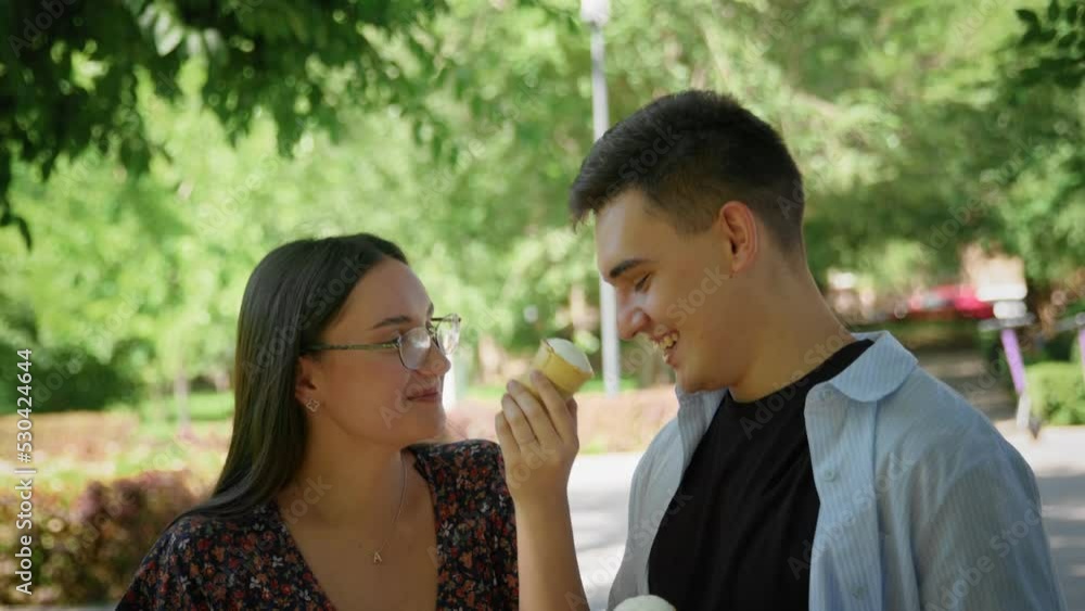 A guy and a girl eat ice cream in a city park A guy and a girl eat ice cream in a city park
