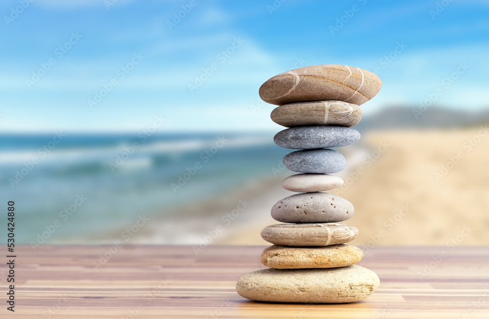 Fototapeta premium Stacked pebbles to make shape of hourglass as a symbol of time management. Concept of meditation, slow down and controlling time.