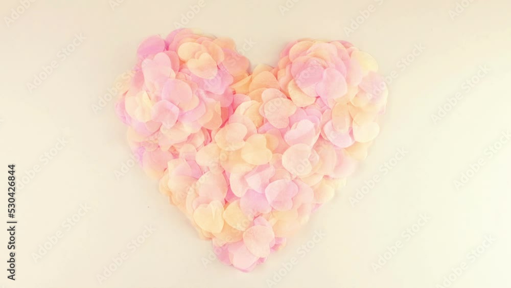Heart-shaped confetti flies in the wind. Slow motion. Heart-shaped confetti flies in the wind. Slow motion.