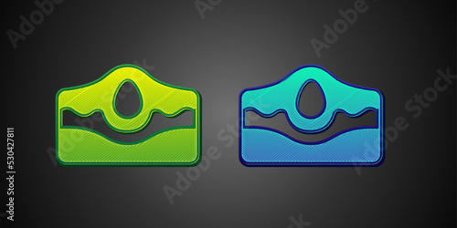 Green and blue Acne icon isolated on black background. Inflamed pimple on the skin. The sebum in the clogged pore promotes the growth of a bacteria. Vector