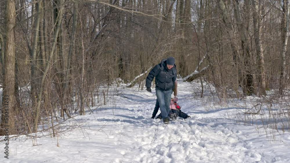 Happy family sledding in a beautiful snowy park. Family enjoying winter day in forest. Winter holidays Happy family sledding in a beautiful snowy park. Family enjoying winter day in forest. Winter holidays