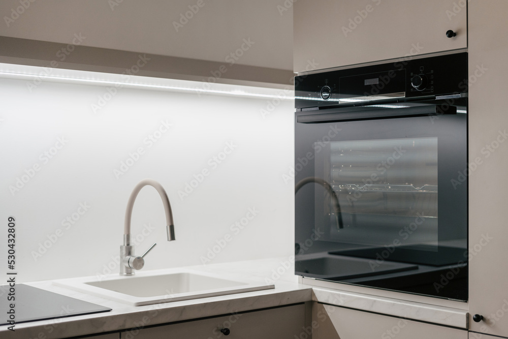 Black built-in oven and sink in kitchen Black built-in oven and sink in kitchen