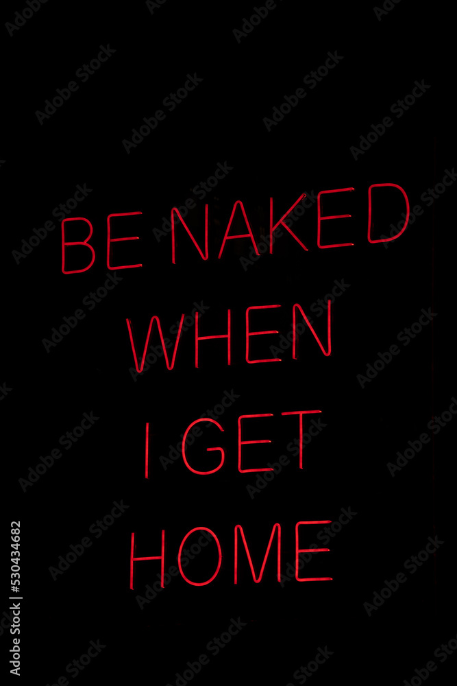 Isolated red neon sign that says be naked when i get home