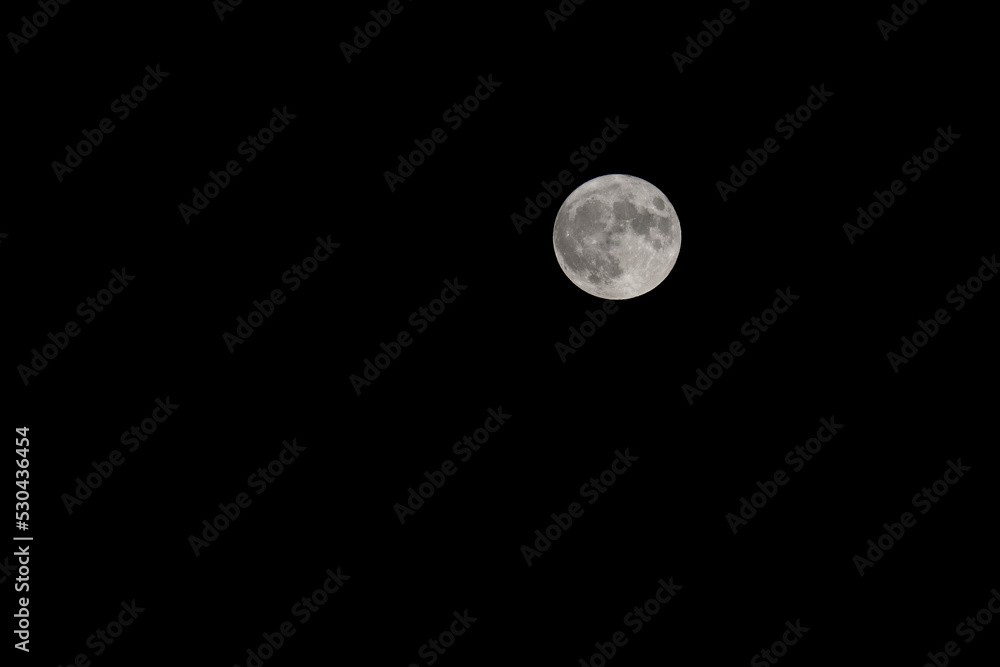 bright full moon and craters are seen in the black starless sky bright full moon and craters are seen in the black starless sky